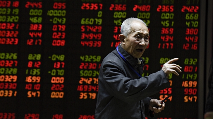 An investor gestures in front of an electronic board showing stock information at a brokerage house in Beijing on January 18, 2016. Shanghai stocks ended higher January 18 after plunging almost nine percent last week, while investors await the release of 2015 economic growth figures out of China. AFP PHOTO / FRED DUFOUR / AFP / FRED DUFOUR